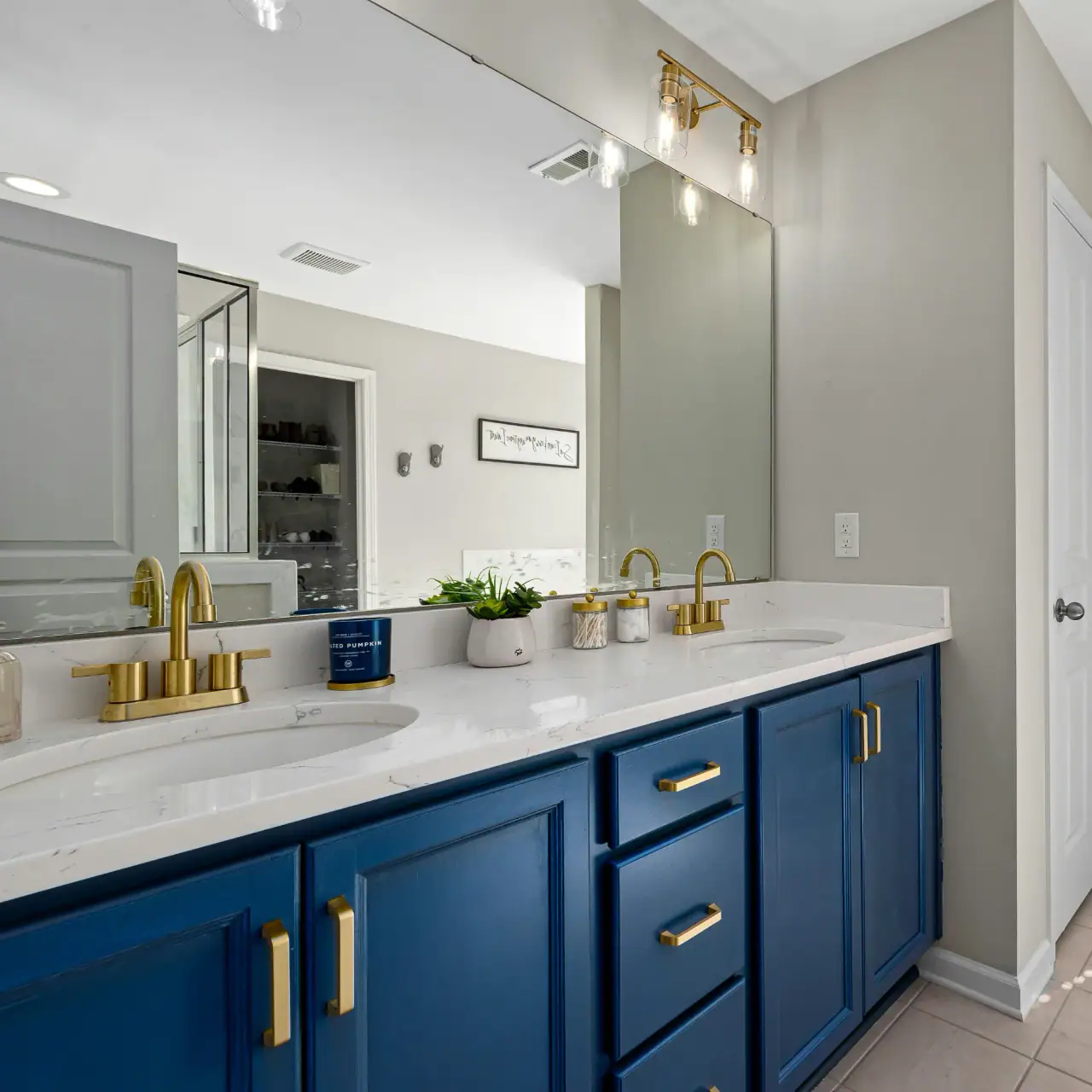 Remodeled bathroom with a blue vanity and new lighting